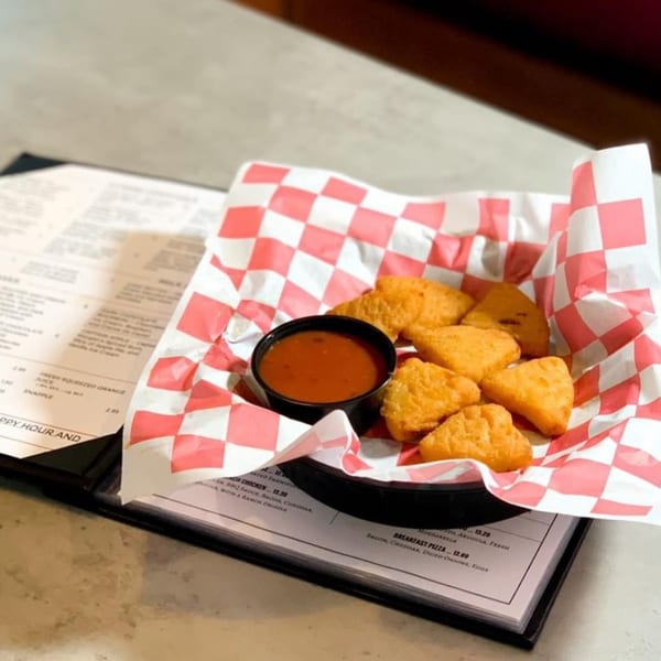 Bel Aire Diner's fried cheese curds with dipping sauce in a red and white checkered basket.